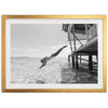 a black and white photo of a person diving into the water