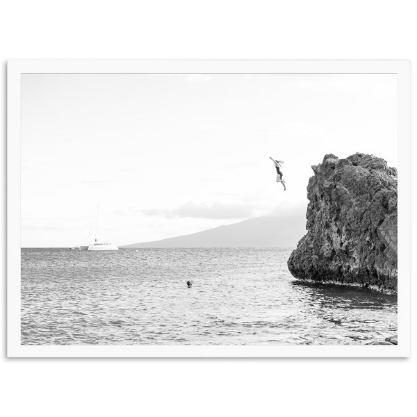 a person jumping off a cliff into the ocean