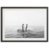 a black and white photo of a person swimming in the ocean