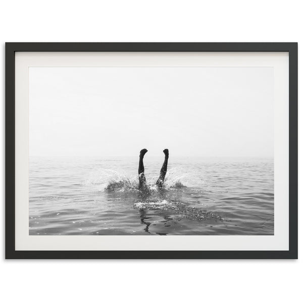 a black and white photo of a person swimming in the ocean