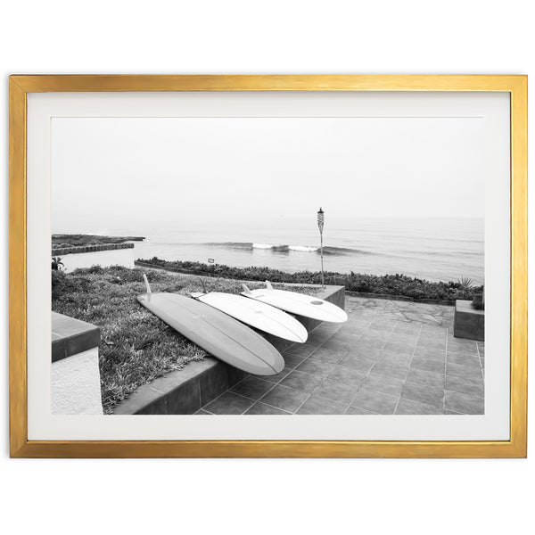 a black and white photo of two surfboards on a bench