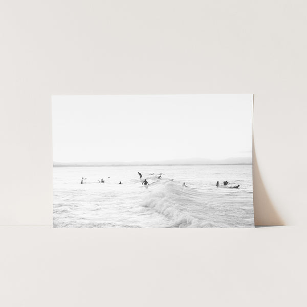 a black and white photo of surfers in the ocean