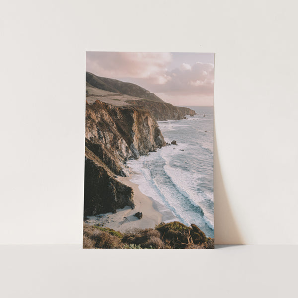 a picture of a beach with a cliff in the background