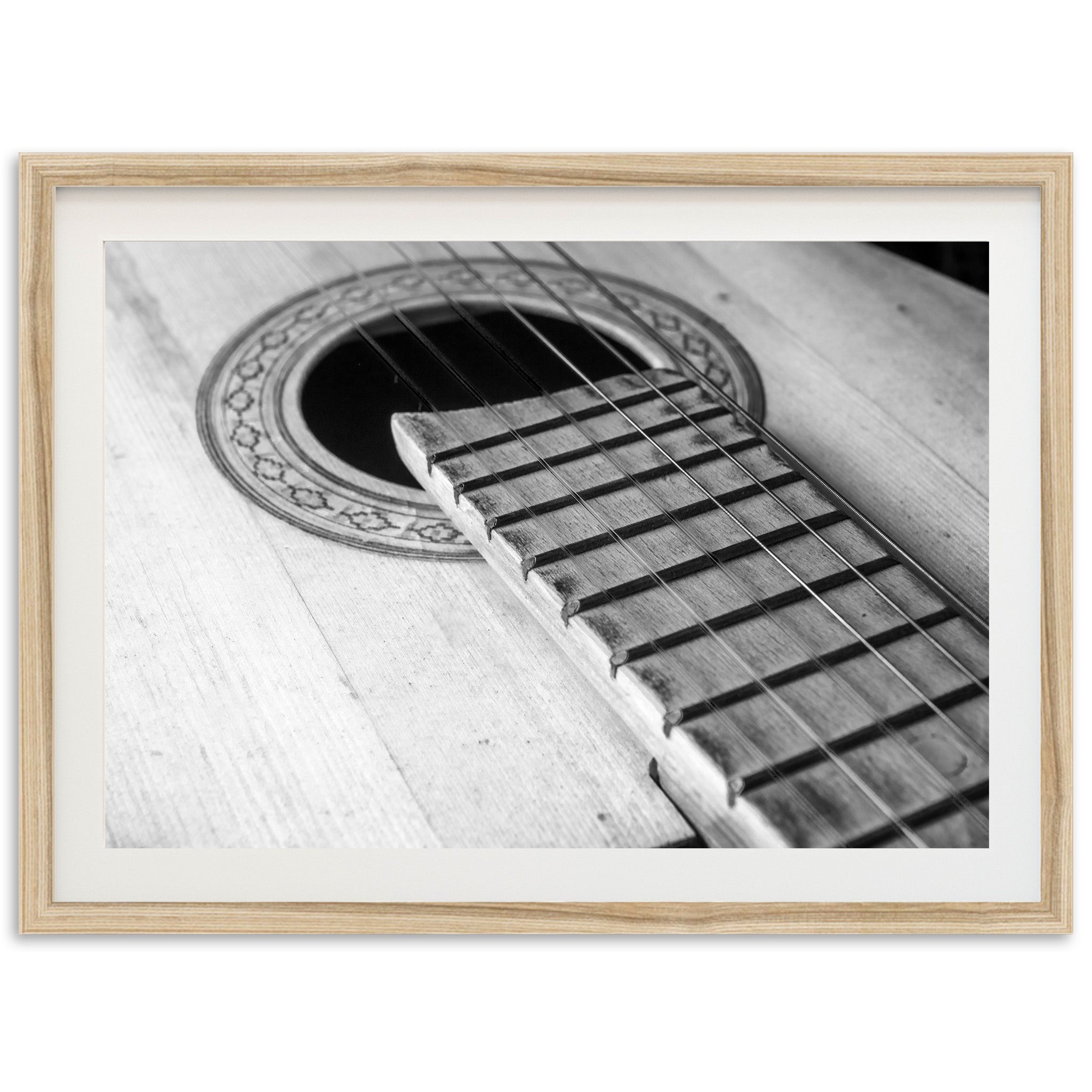 a black and white photo of an acoustic guitar