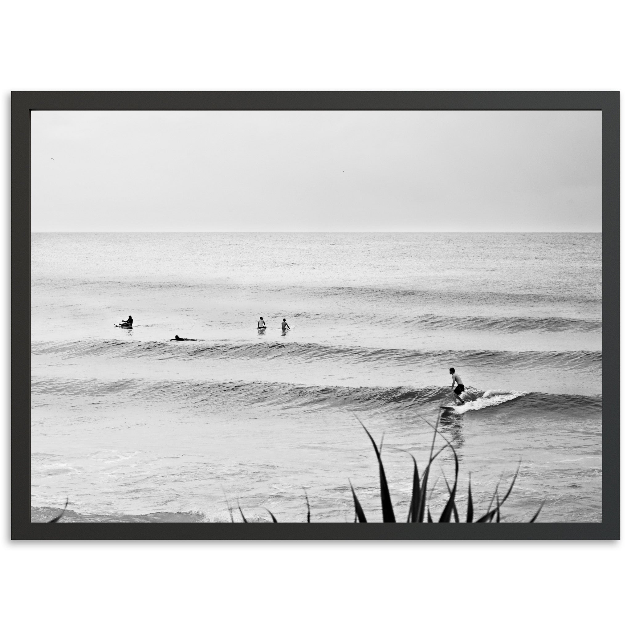 a black and white photo of surfers in the ocean