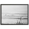 a black and white photo of surfers in the ocean