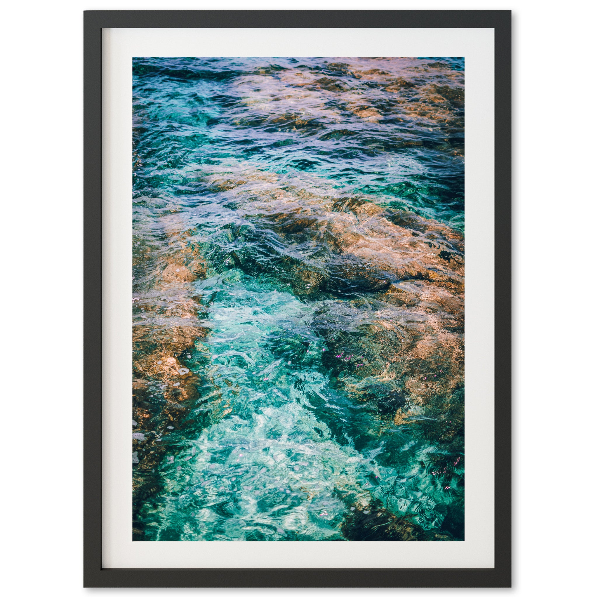 a framed photograph of water and rocks