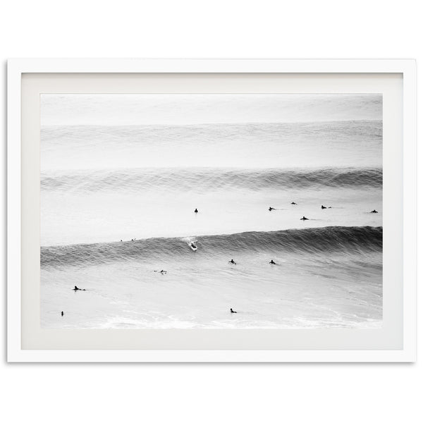 a black and white photo of surfers in the ocean