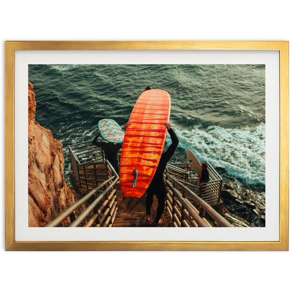 a man carrying a surfboard down a flight of stairs