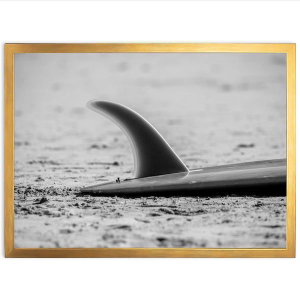 a black and white photo of a surfboard on the beach