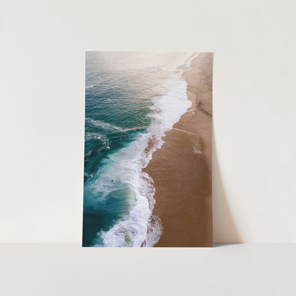 an aerial view of a beach with waves coming in