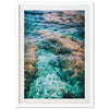 a framed photograph of water and rocks in the ocean