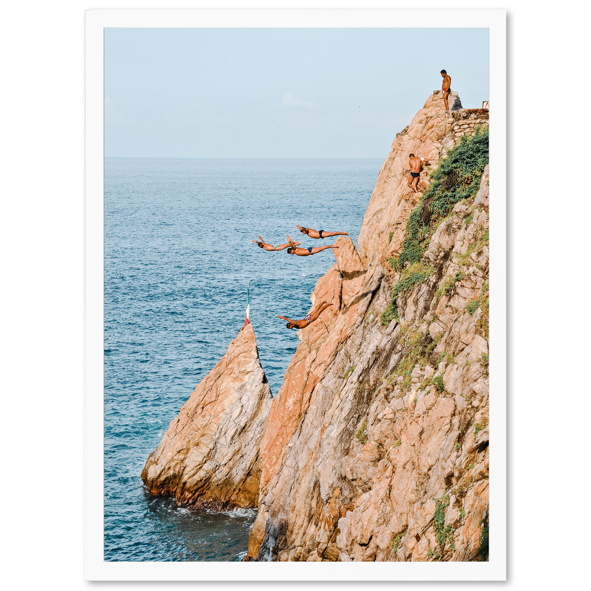 a group of people jumping off of a cliff into the ocean