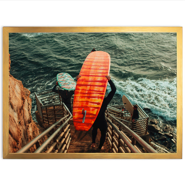 a man carrying a surfboard down a flight of stairs