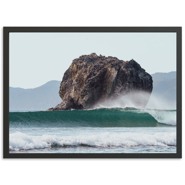 a large rock sticking out of the ocean