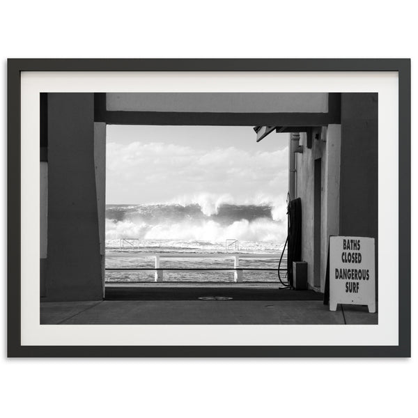 a black and white photo of a wave coming in from the ocean