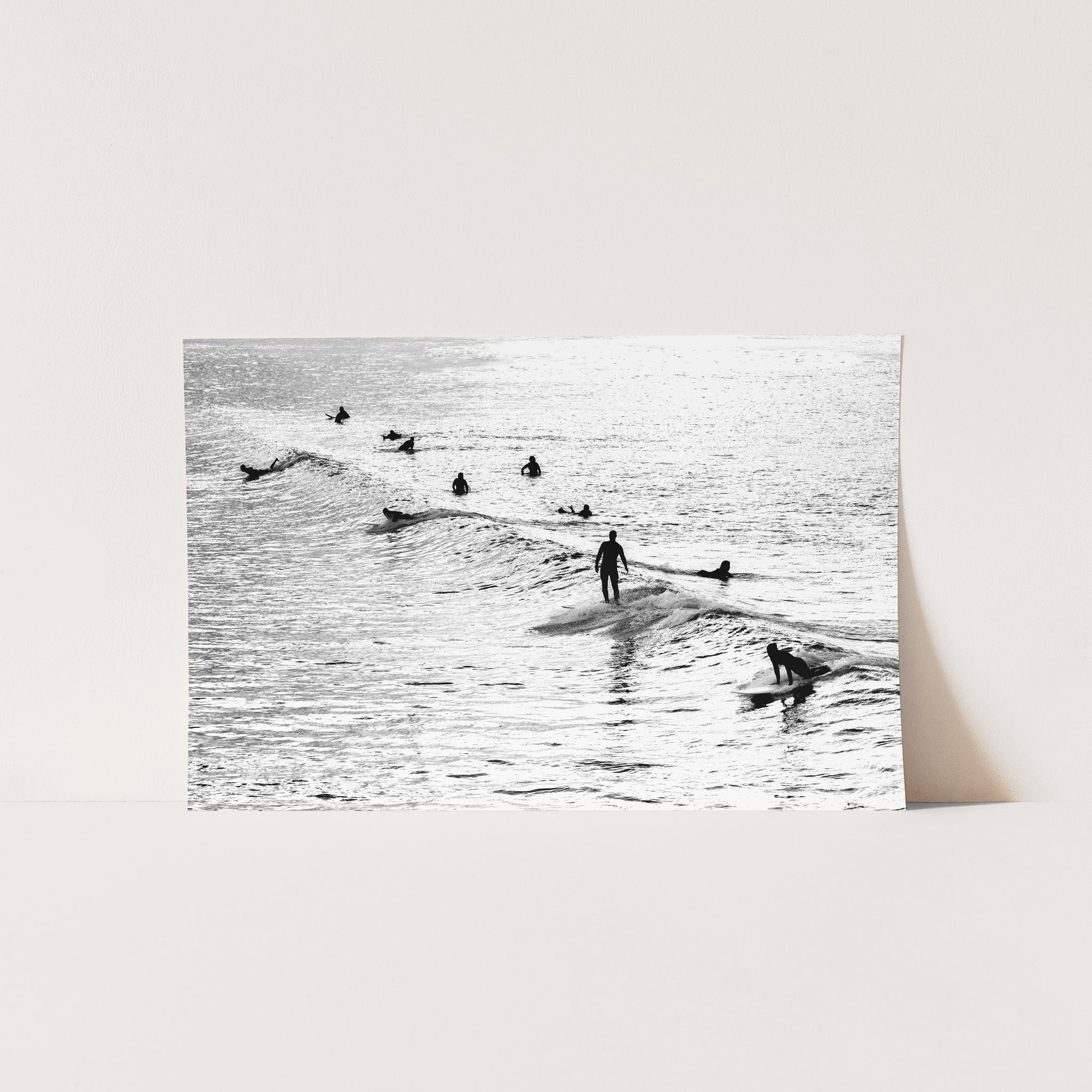 a black and white photo of surfers in the ocean