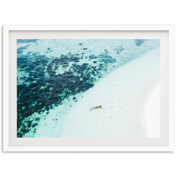 an aerial view of a beach with a boat in the water