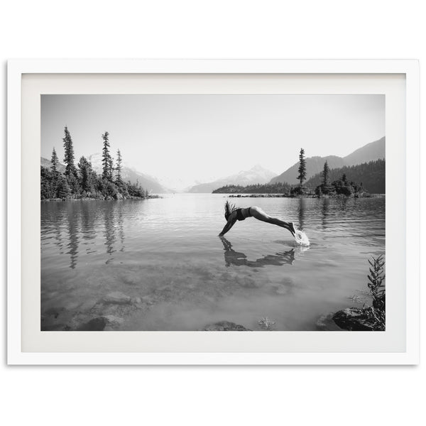 a black and white photo of a person diving into a lake