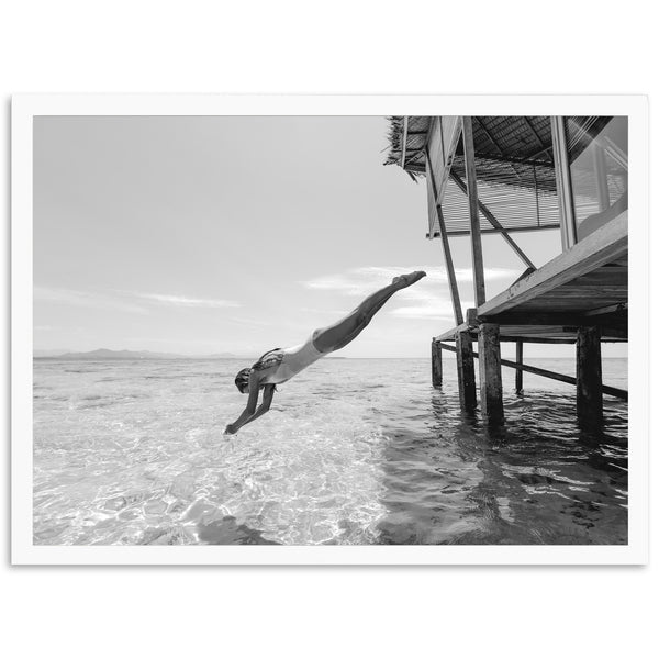 a man diving into the ocean from a pier