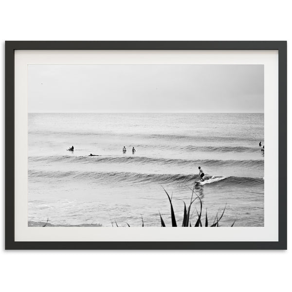 a black and white photo of surfers in the ocean