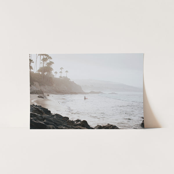 a picture of a beach with a person in the water