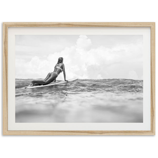 a woman laying on a surfboard in the ocean