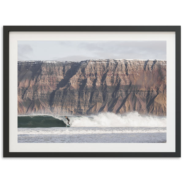 a man riding a wave on top of a surfboard