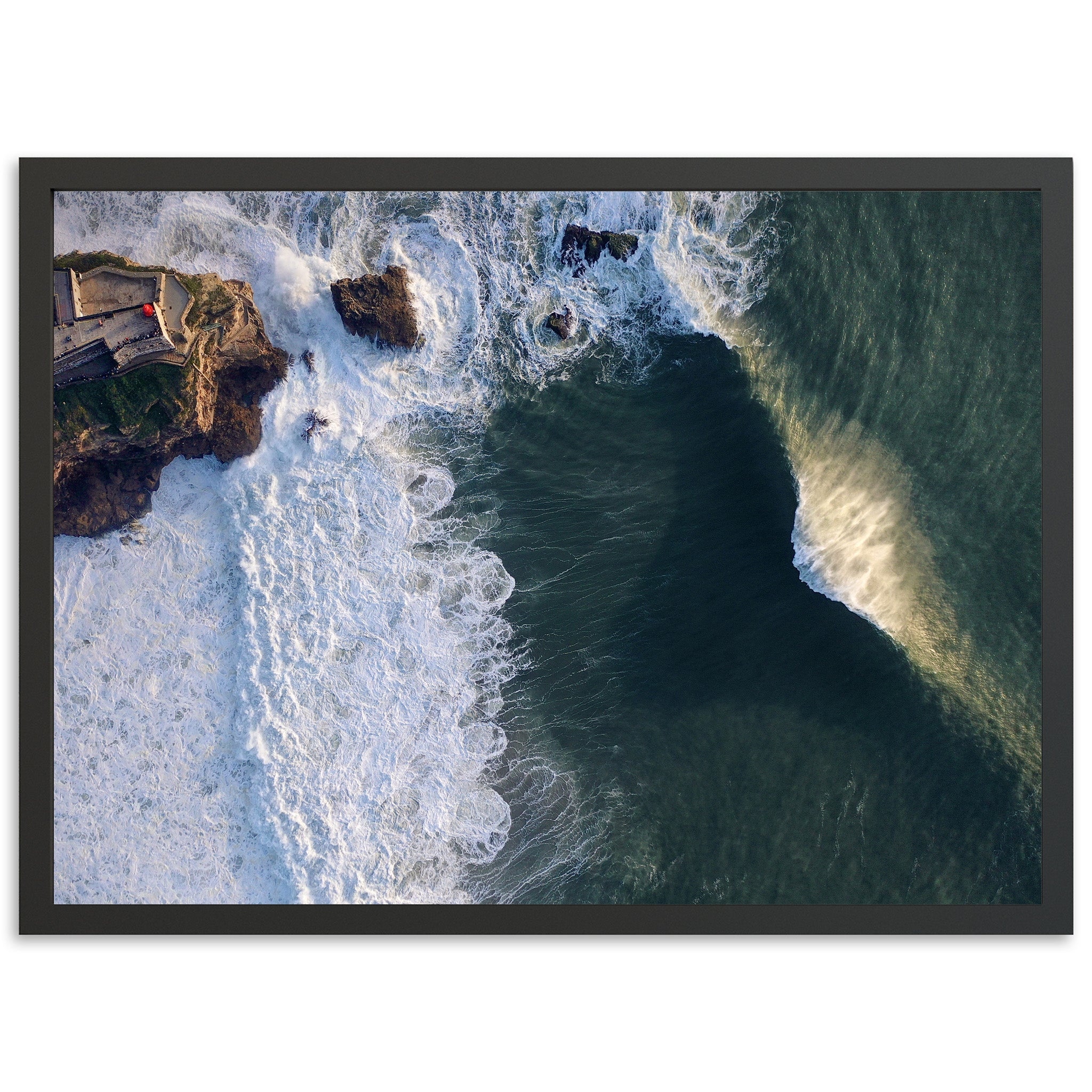 an aerial view of a wave crashing into the shore