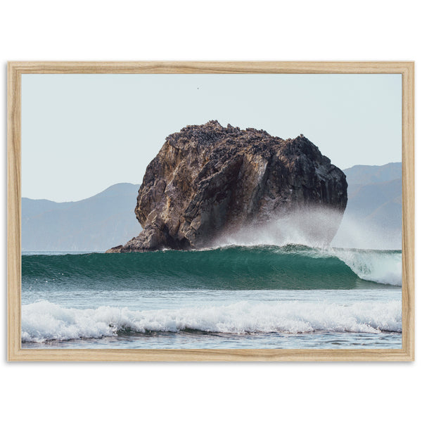 a large rock sticking out of the ocean