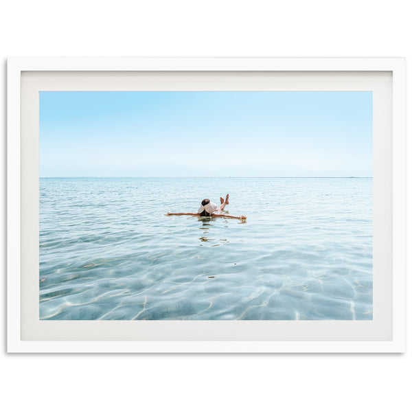 a person sitting on a surfboard in the middle of the ocean