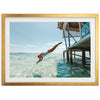 a man diving into the ocean from a dock