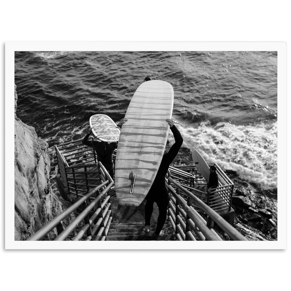 a black and white photo of a person holding a surfboard