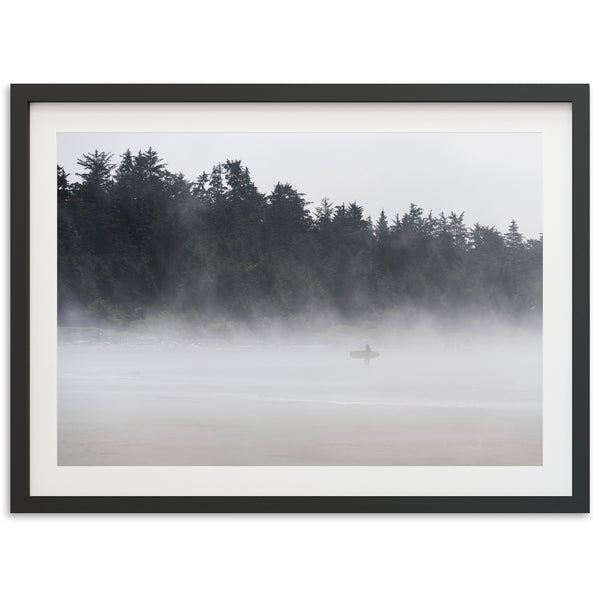 a picture of a person standing on a beach in the fog