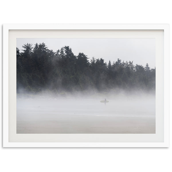 a person standing on a beach in the fog