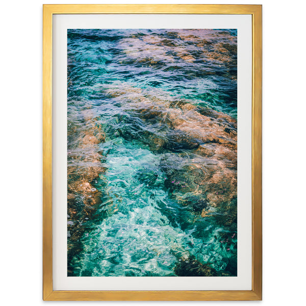 a framed photograph of water and rocks