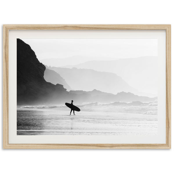 a black and white photo of a person holding a surfboard