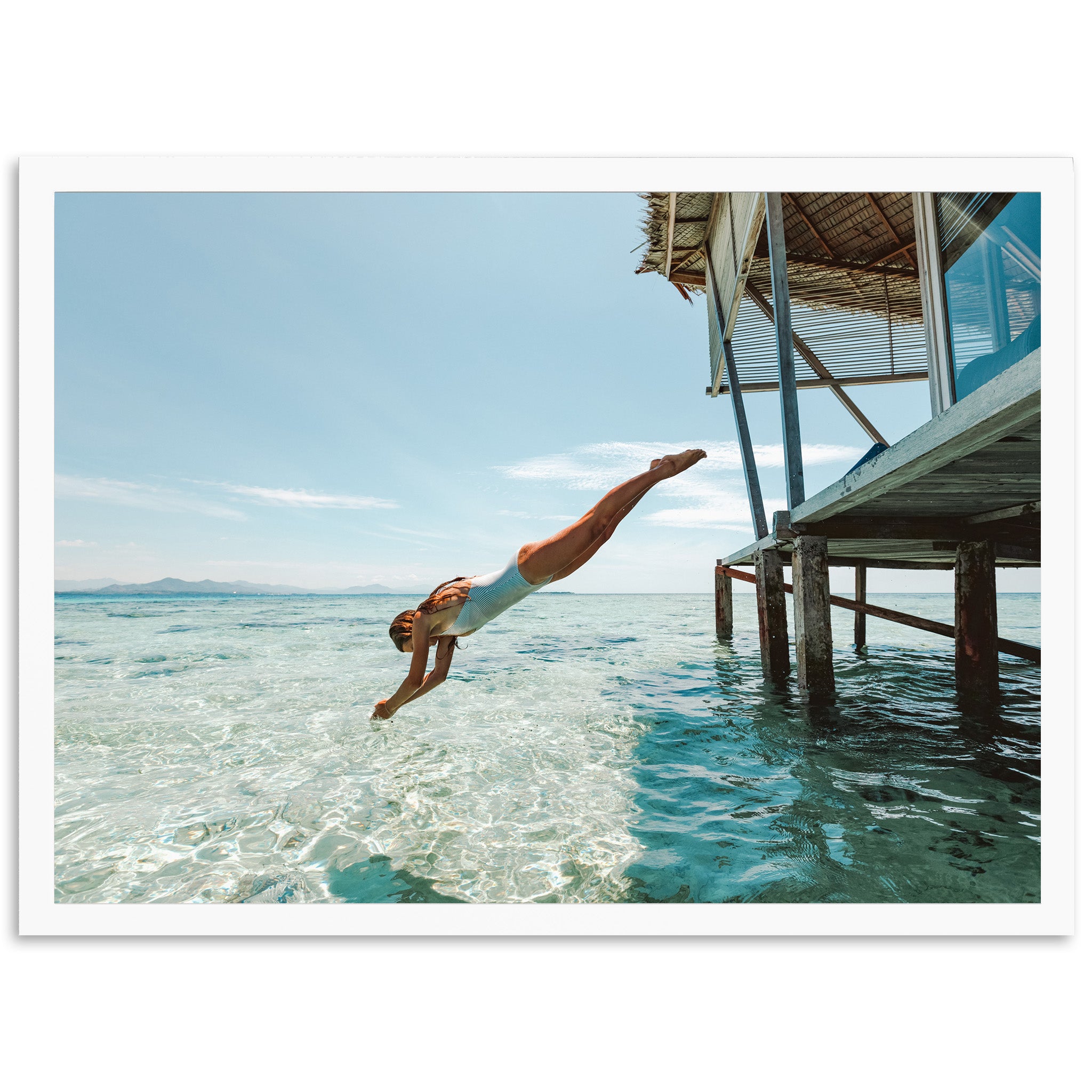 a man diving into the ocean from a dock