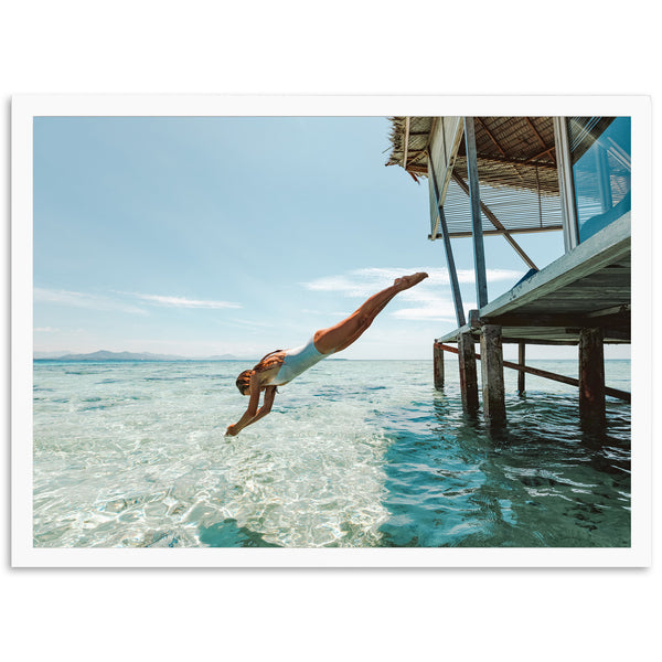 a man diving into the ocean from a dock