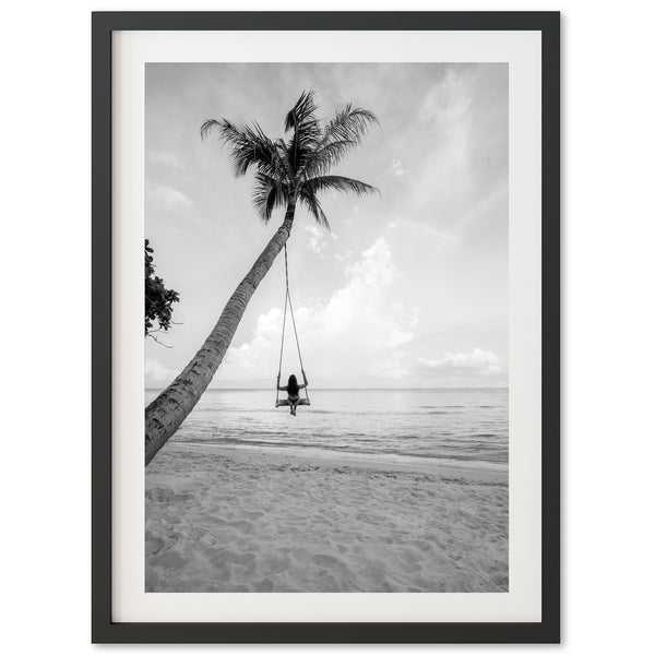 a black and white photo of a person swinging on a palm tree