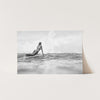 a black and white photo of a woman laying on a surfboard