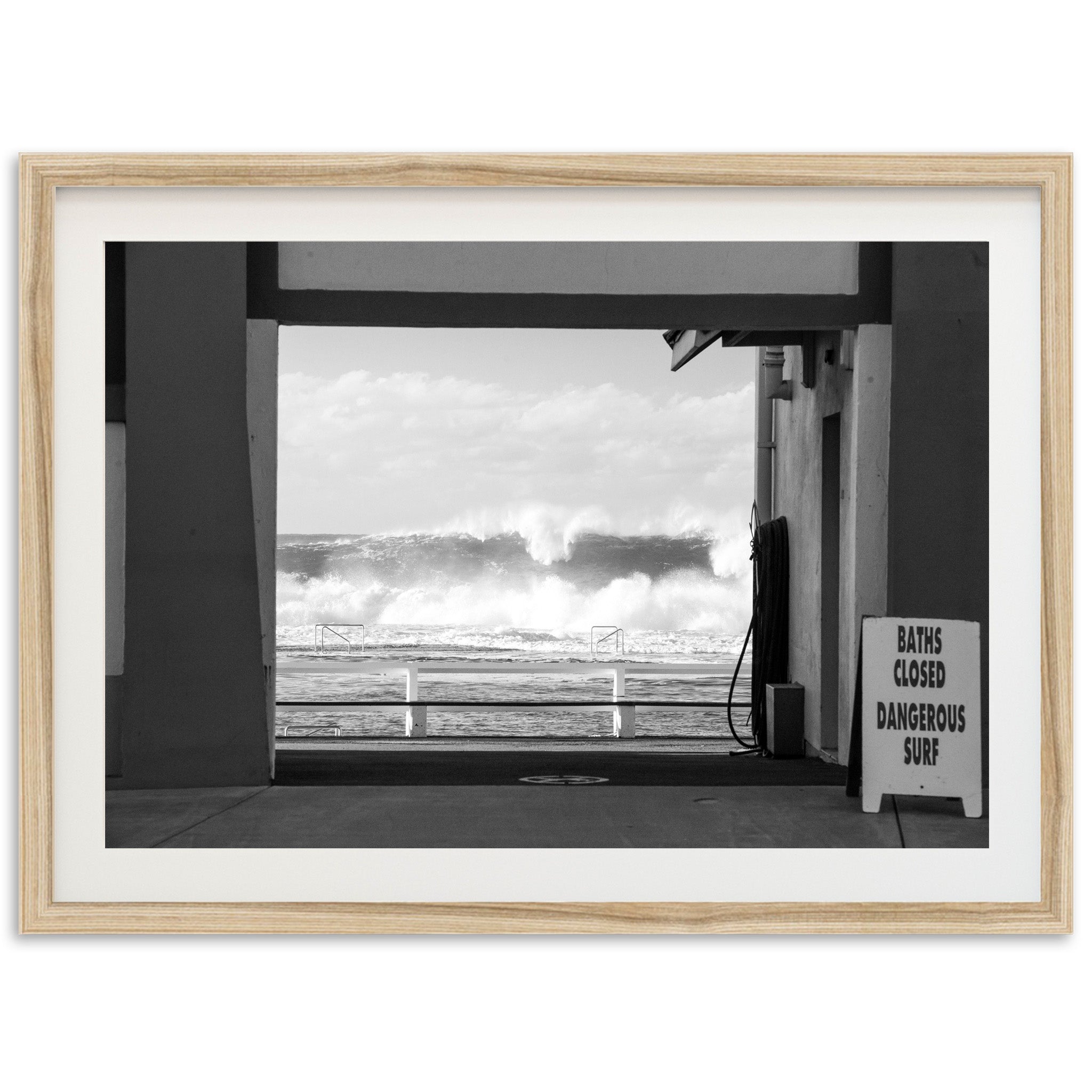 a black and white photo of a wave coming in from the ocean