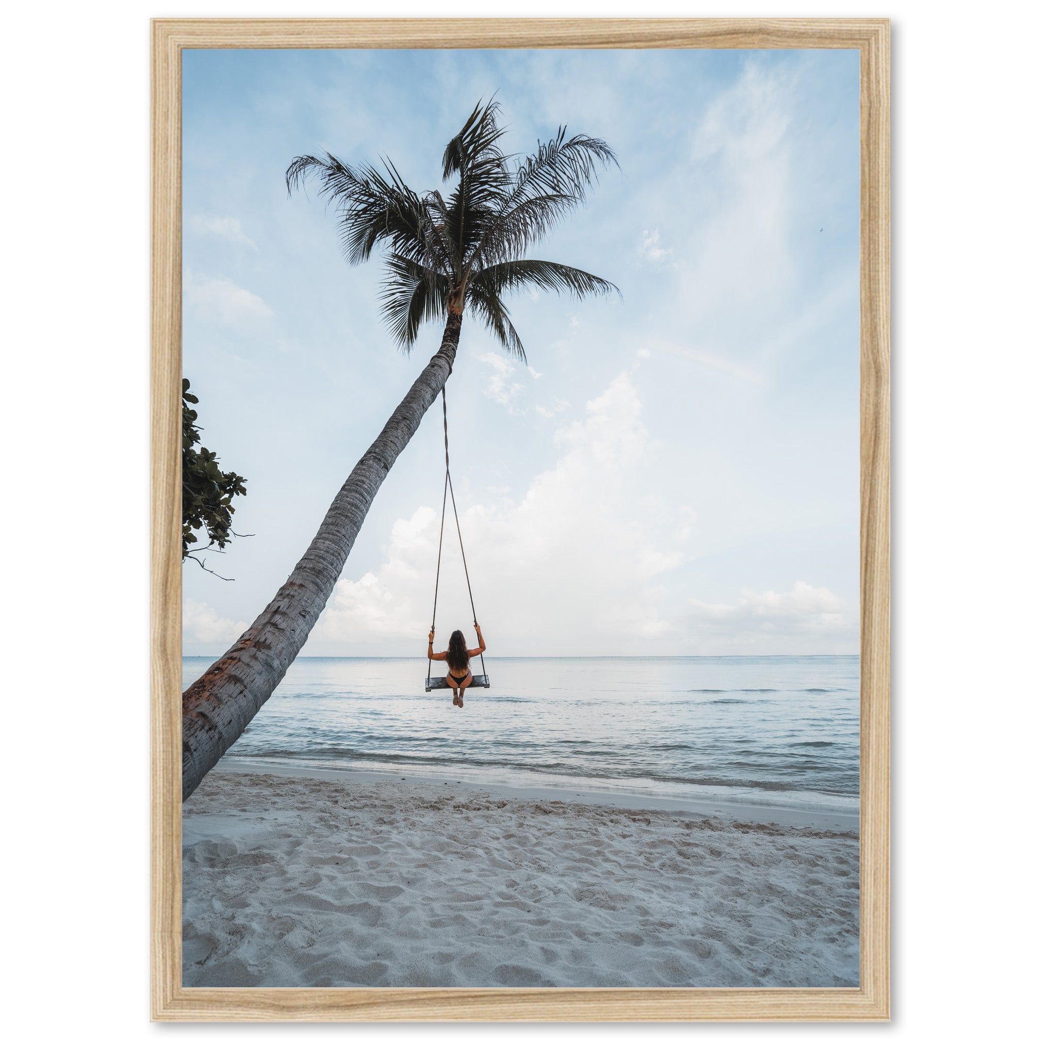 a woman sitting on a swing between two palm trees