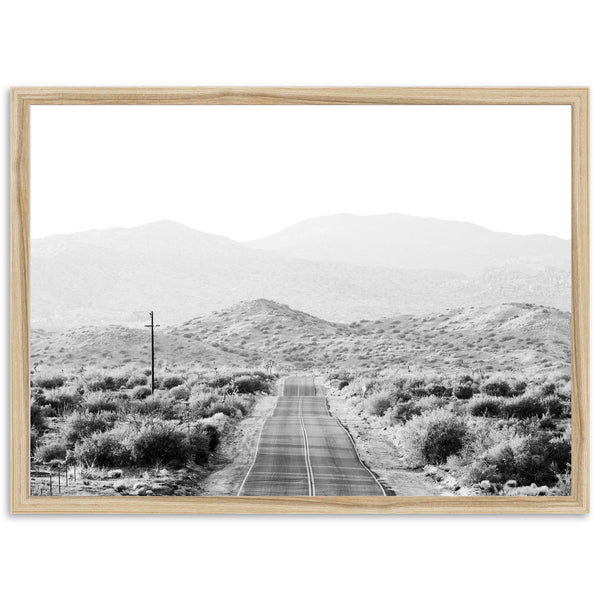 a black and white photo of a road in the desert