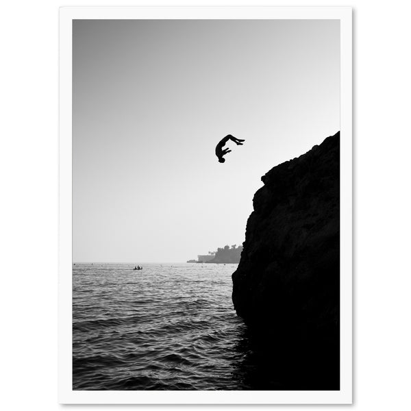 a black and white photo of a bird flying over the ocean