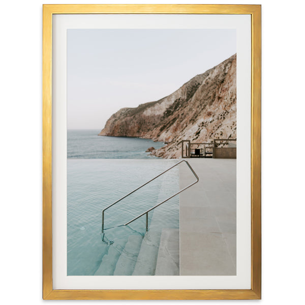 a framed photograph of a swimming pool with stairs leading to the water