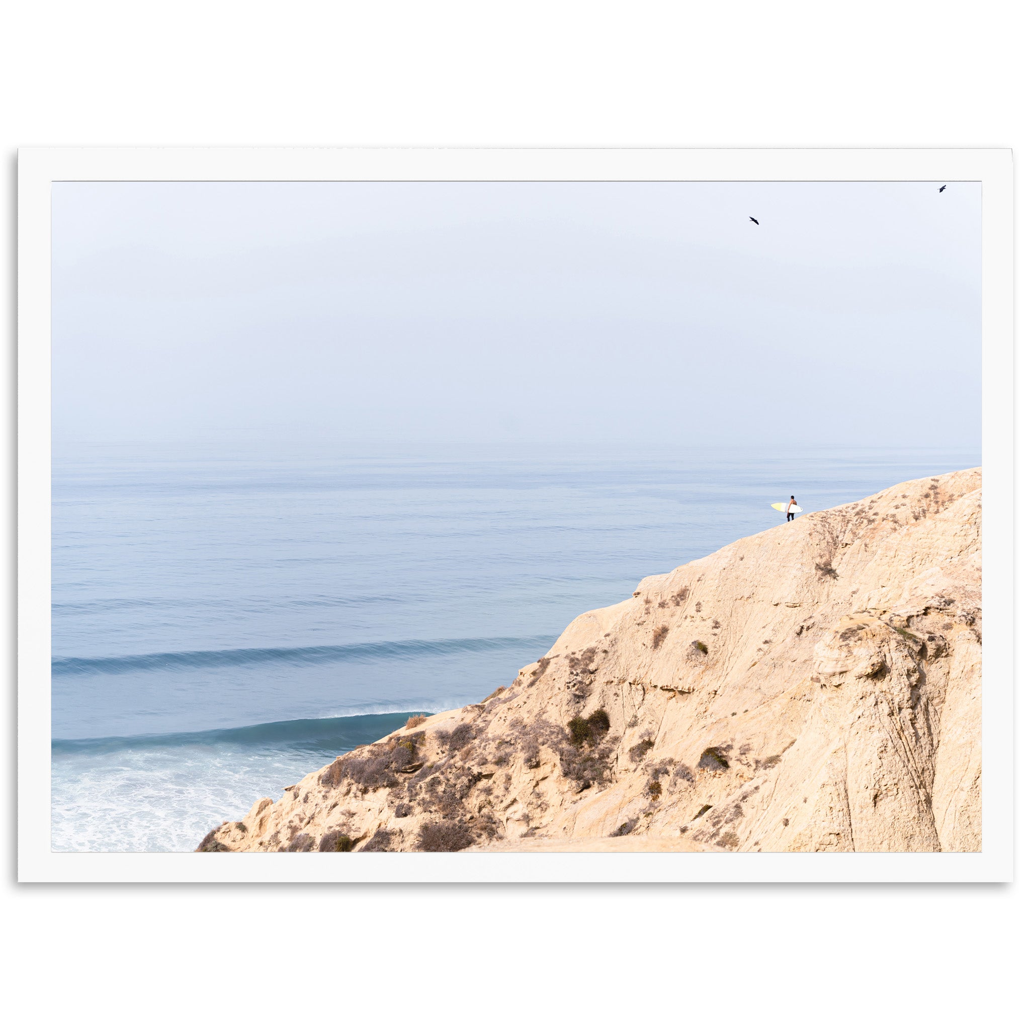 a person standing on top of a cliff next to the ocean