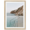 a framed photograph of a swimming pool with a mountain in the background