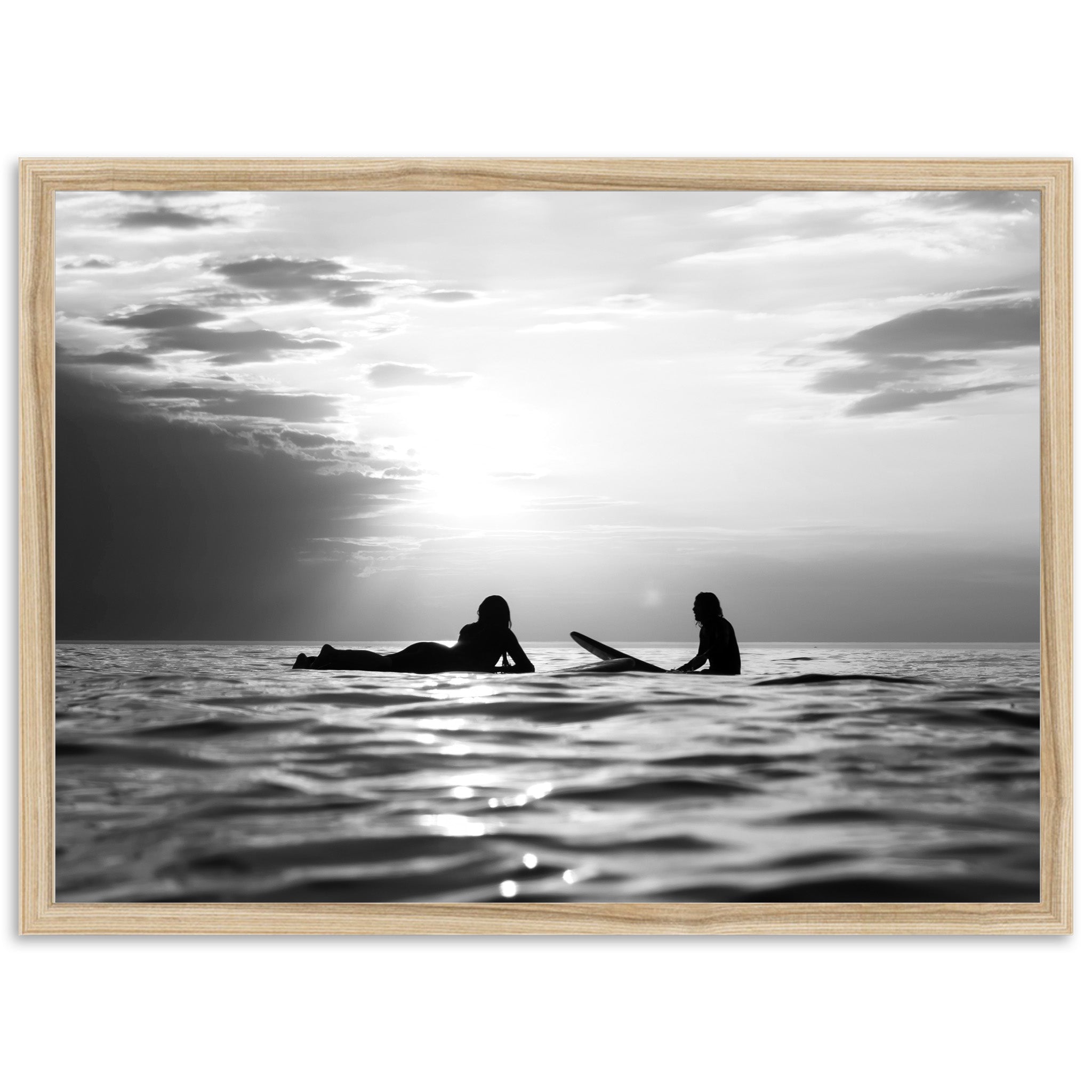 a black and white photo of two people on surfboards