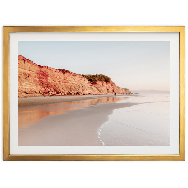 a picture of a beach with a cliff in the background